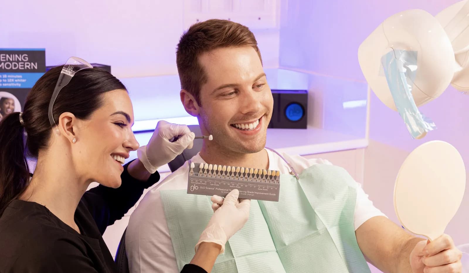 Dental team member matching a patient's tooth shade with a GLO shade guide