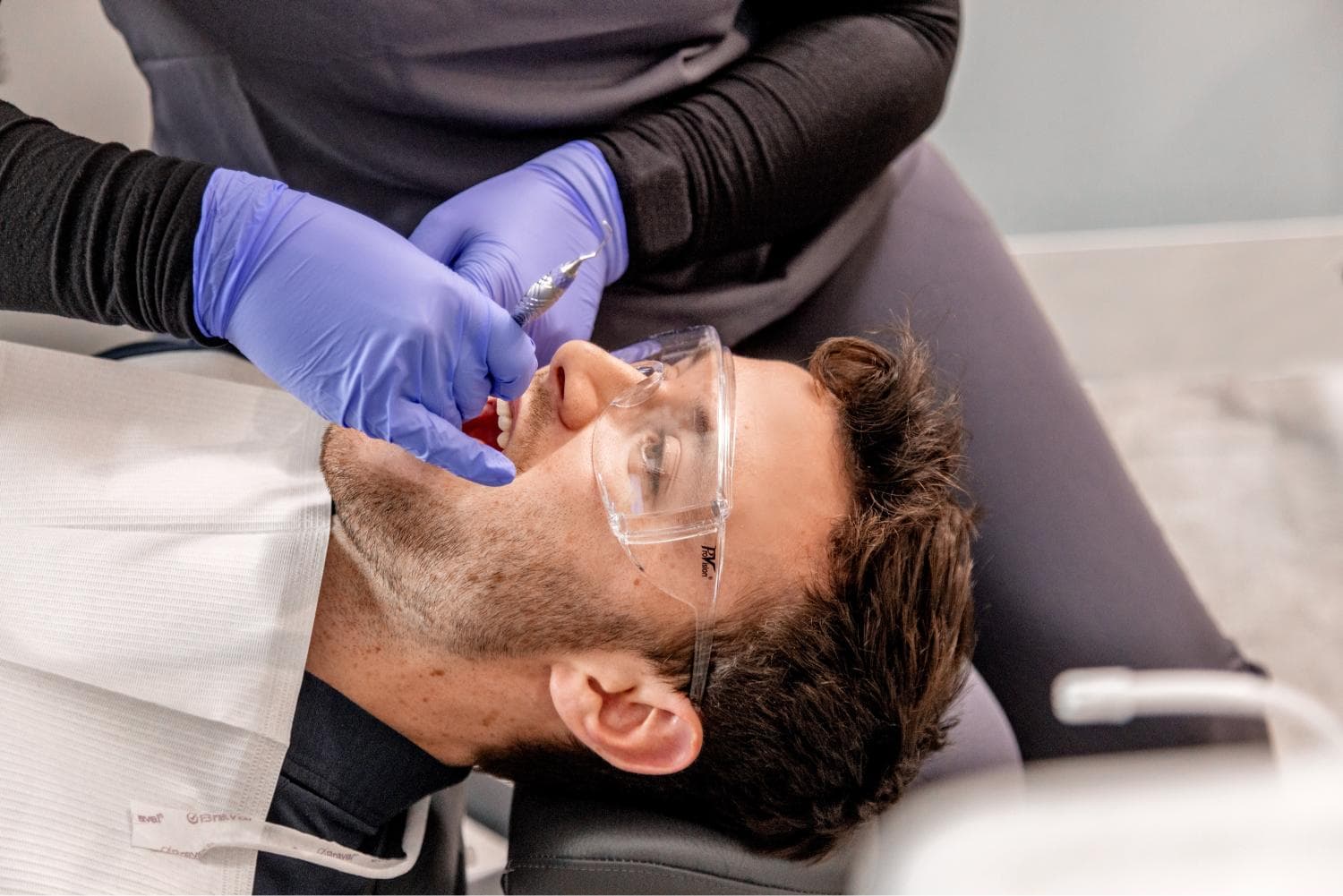 Young adult man receiving a routine dental cleaning at Miller Dental Care under CDCP coverage.